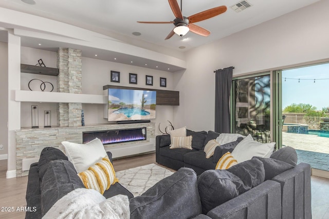 8725 E Menlo Cir, Mesa, AZ 85207 - living room featuring wood finished floors, ceiling fan, a glass covered fireplace, and recessed lighting