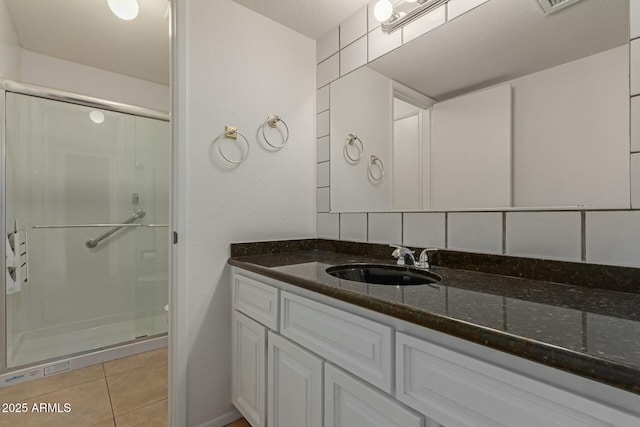 bathroom featuring a stall shower, tile patterned flooring, and vanity