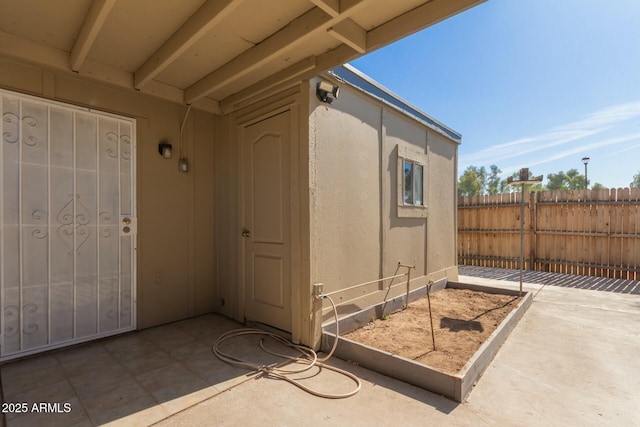 property entrance with fence and stucco siding