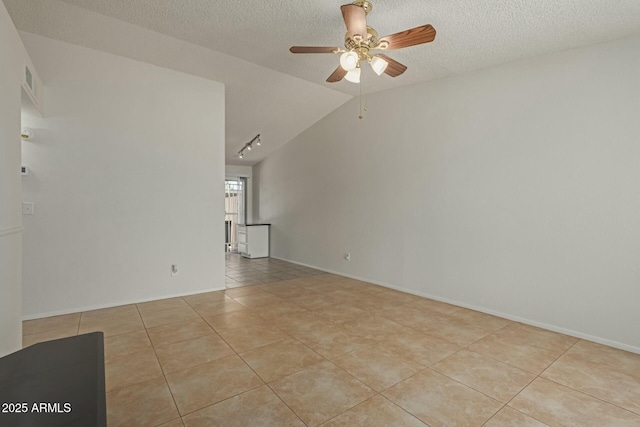 unfurnished room with light tile patterned floors, a ceiling fan, vaulted ceiling, a textured ceiling, and track lighting