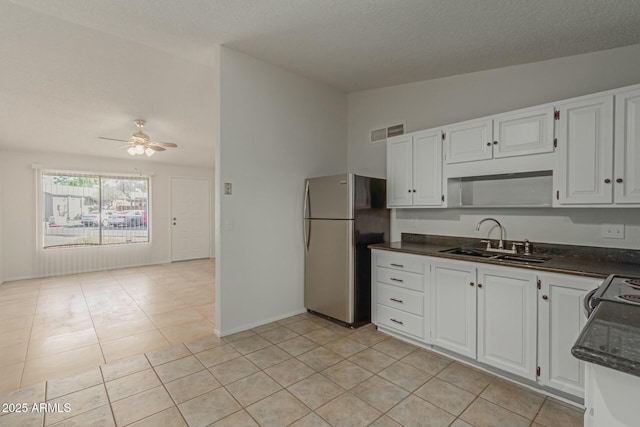 kitchen with ceiling fan, white cabinets, a sink, and freestanding refrigerator