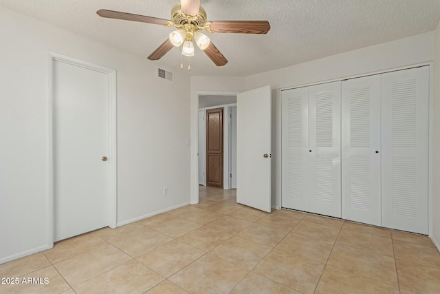 unfurnished bedroom with visible vents, ceiling fan, a textured ceiling, and light tile patterned flooring