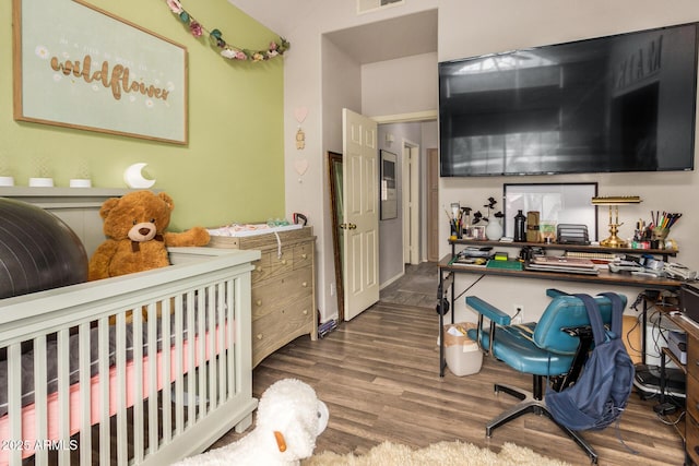 bedroom featuring a crib and wood-type flooring