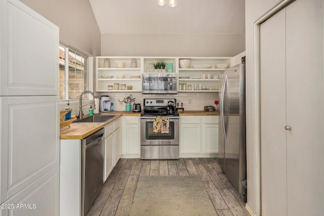 kitchen with white cabinets, sink, butcher block counters, and stainless steel appliances