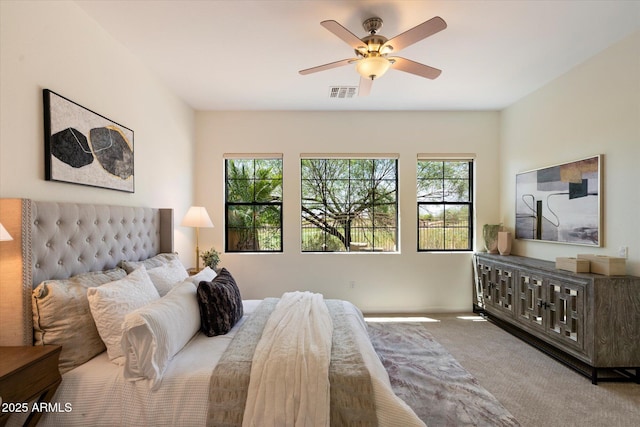 carpeted bedroom with visible vents and ceiling fan