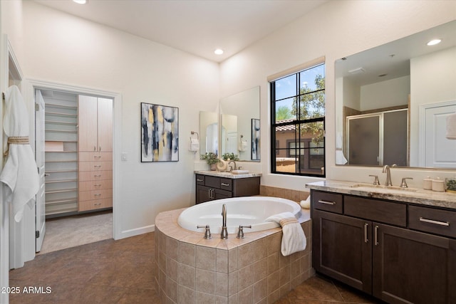 full bath featuring a sink, tile patterned flooring, two vanities, a bath, and a stall shower