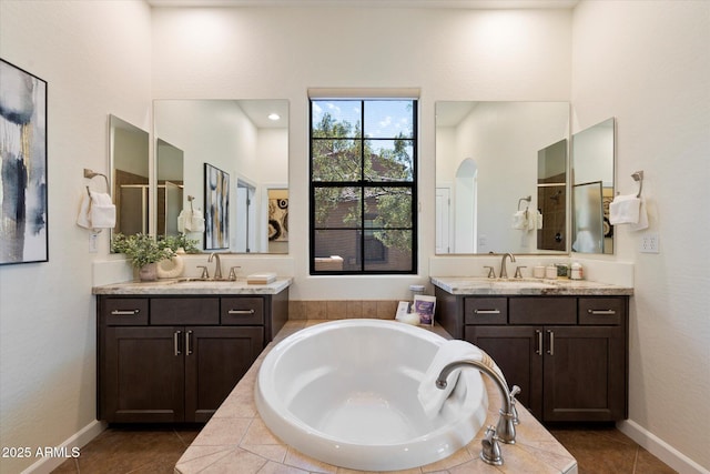 full bath featuring a sink, tile patterned flooring, a bath, and two vanities