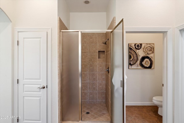 bathroom with tile patterned floors, a stall shower, and toilet