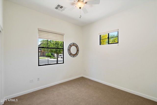 spare room with visible vents, baseboards, plenty of natural light, and carpet floors