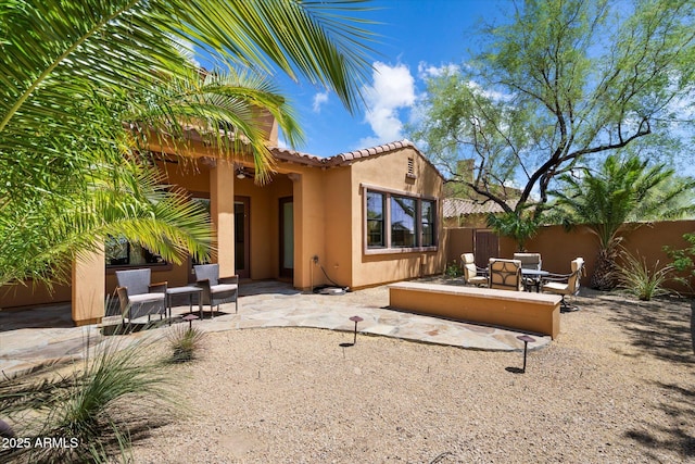 rear view of property with a patio area, stucco siding, a tile roof, and fence