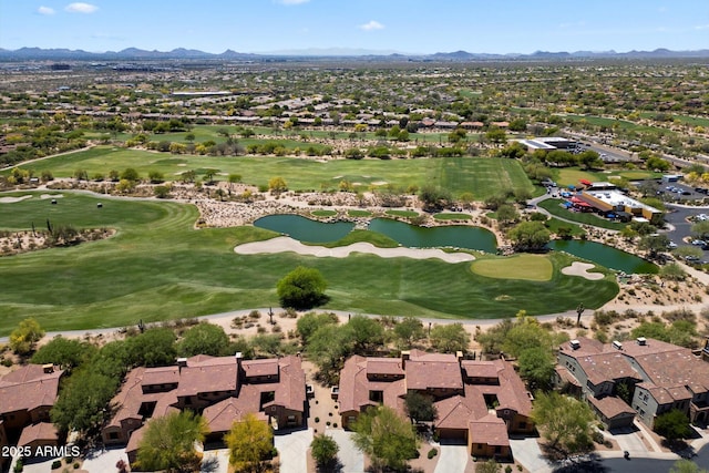 drone / aerial view featuring view of golf course, a residential view, and a water and mountain view