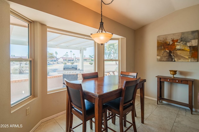 dining space featuring vaulted ceiling and light tile patterned flooring