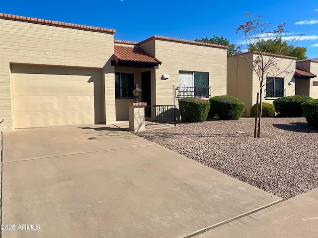 4502 E Carol Ave Unit 4, Mesa, AZ 85206 - view of front of home with driveway, brick siding, a tiled roof, and a garage