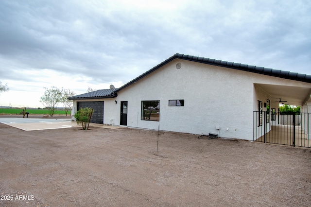 view of property exterior with ceiling fan and a garage