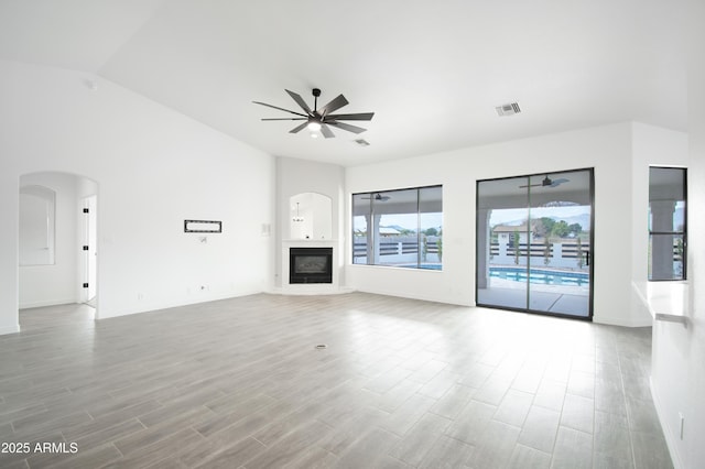 unfurnished living room with lofted ceiling, light hardwood / wood-style flooring, and ceiling fan