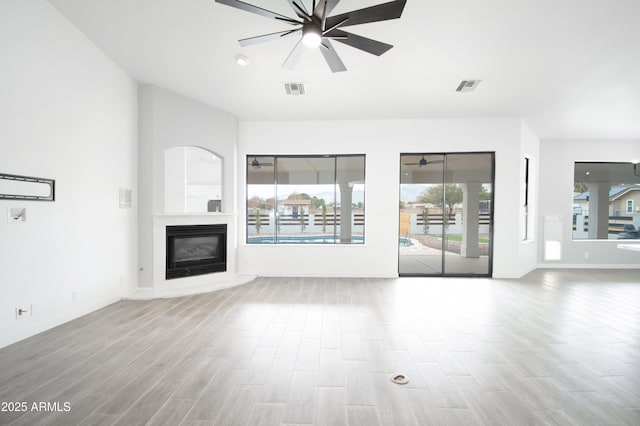 unfurnished living room featuring ceiling fan and light hardwood / wood-style flooring