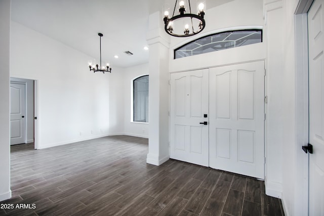 foyer with dark wood-type flooring and a chandelier