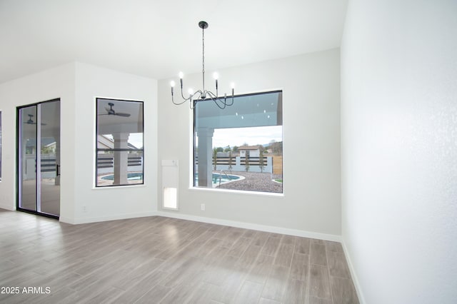 unfurnished dining area with an inviting chandelier and hardwood / wood-style floors