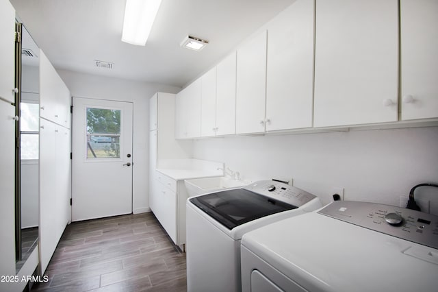 washroom featuring cabinets and independent washer and dryer