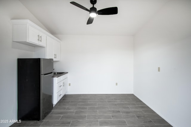 kitchen with white cabinetry, stainless steel fridge, and ceiling fan