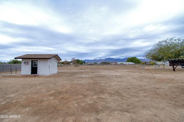 view of yard with a rural view, a mountain view, and a storage shed