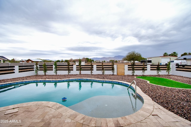 view of swimming pool with a mountain view and a patio area