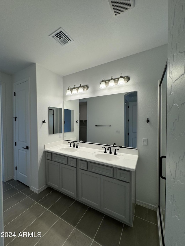 24066 N 162nd Ln, Surprise, AZ 85387 - bathroom with tile patterned floors, double vanity, a shower stall, and baseboards