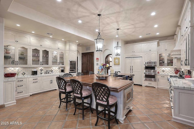 2041 W Hemlock Way, Chandler, AZ 85248 - kitchen with built in appliances, backsplash, recessed lighting, a center island with sink, and a kitchen breakfast bar