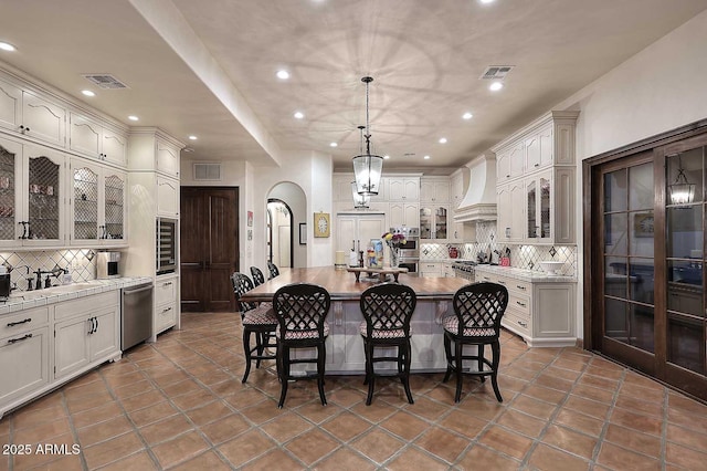2041 W Hemlock Way, Chandler, AZ 85248 - kitchen with appliances with stainless steel finishes, custom exhaust hood, backsplash, a kitchen bar, and recessed lighting