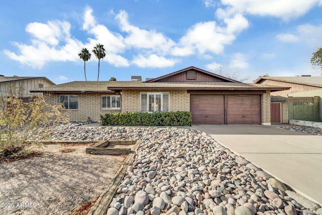 ranch-style home with an attached garage, fence, brick siding, and driveway