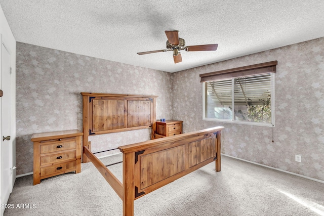 bedroom with carpet flooring, a textured ceiling, wallpapered walls, and a ceiling fan