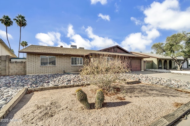 single story home with brick siding, driveway, a garage, and fence