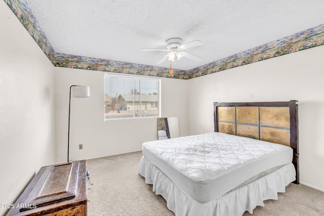 bedroom featuring light colored carpet, a ceiling fan, and a textured ceiling