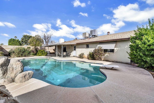 view of pool with a fenced in pool, fence, central AC, a patio area, and a diving board