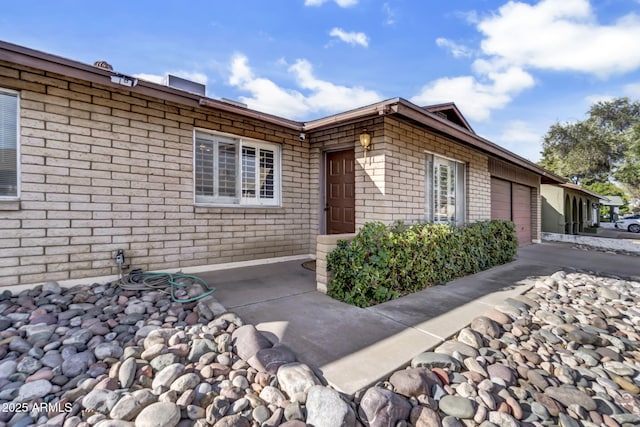 view of home's exterior with brick siding, concrete driveway, and a garage