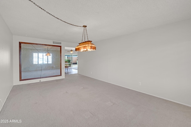 carpeted empty room with visible vents and a textured ceiling