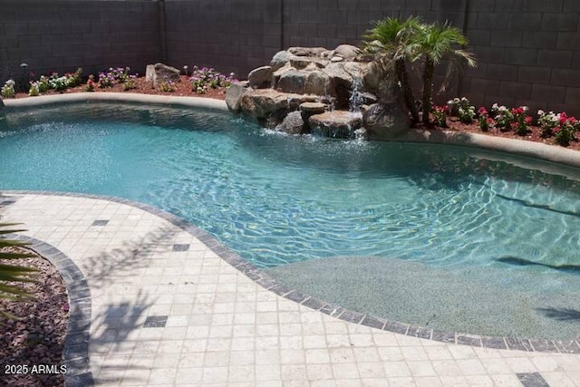 view of swimming pool with pool water feature