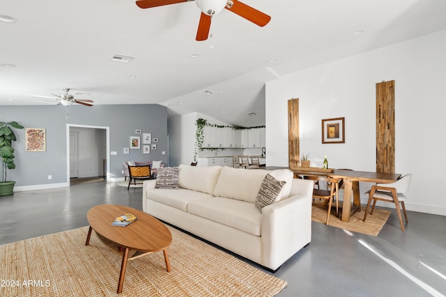 living room with lofted ceiling and concrete flooring