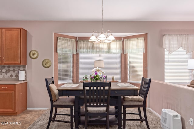 dining room with a chandelier and light tile patterned flooring