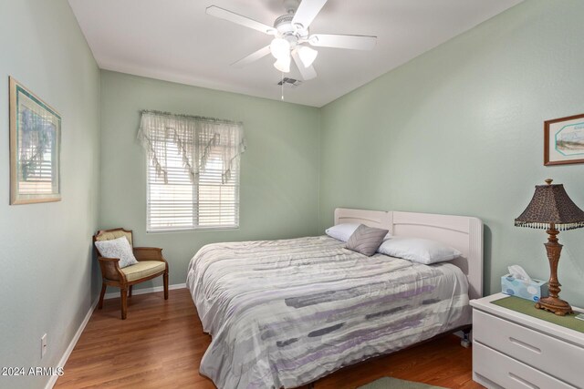 bedroom with vaulted ceiling, ceiling fan, and hardwood / wood-style flooring