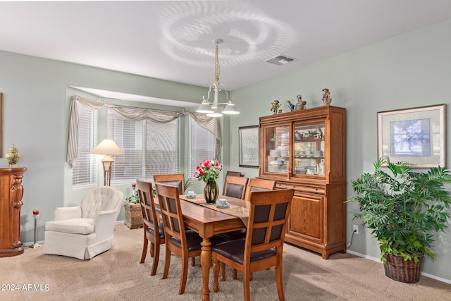 carpeted dining area featuring a notable chandelier