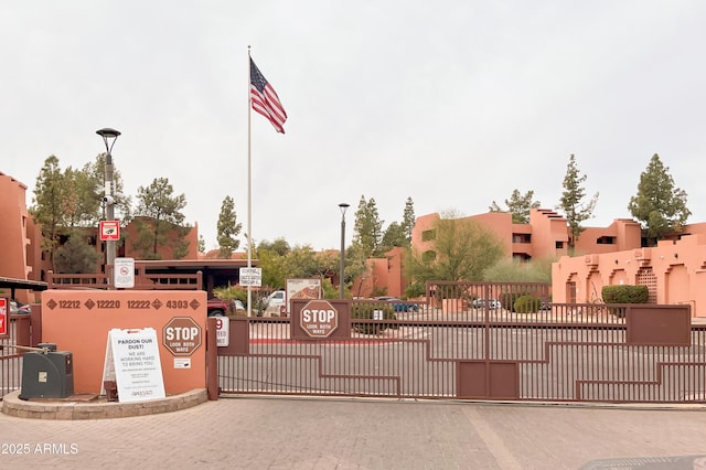 view of street with a gated entry, curbs, street lighting, and a gate