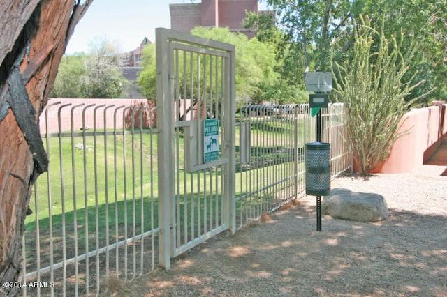 view of gate with a yard and fence