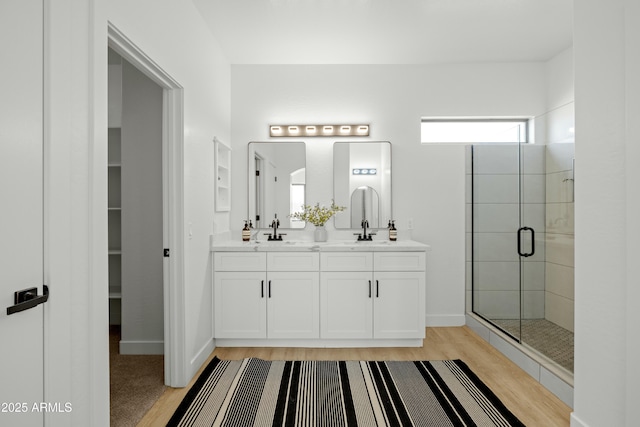 bathroom featuring vanity, a shower with shower door, and hardwood / wood-style floors