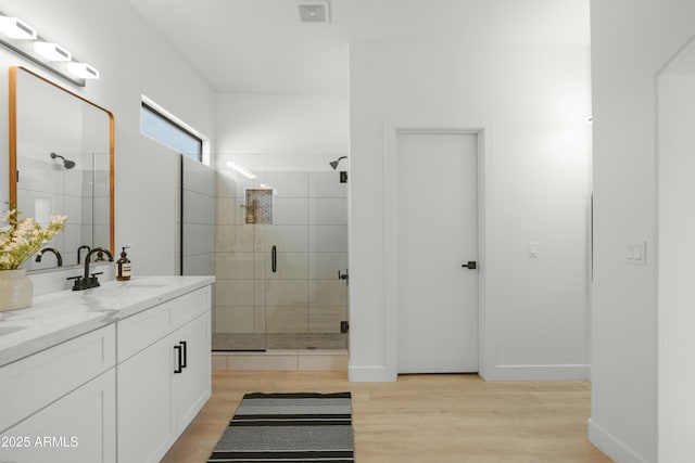 bathroom featuring vanity, hardwood / wood-style floors, and a shower with door