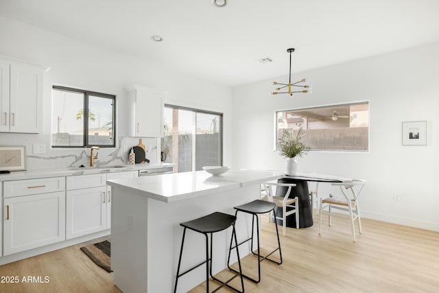 kitchen featuring sink, white cabinetry, and a kitchen island