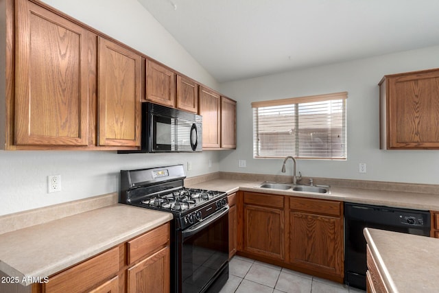 kitchen with black appliances, a sink, light countertops, and brown cabinets