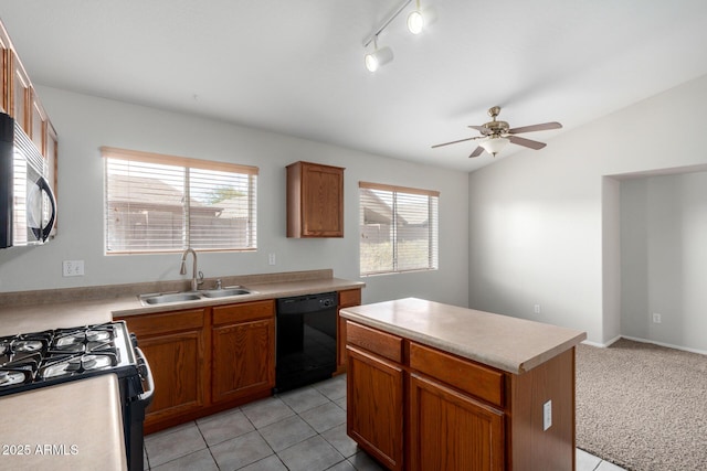 kitchen featuring black dishwasher, brown cabinets, light countertops, a kitchen island, and a sink