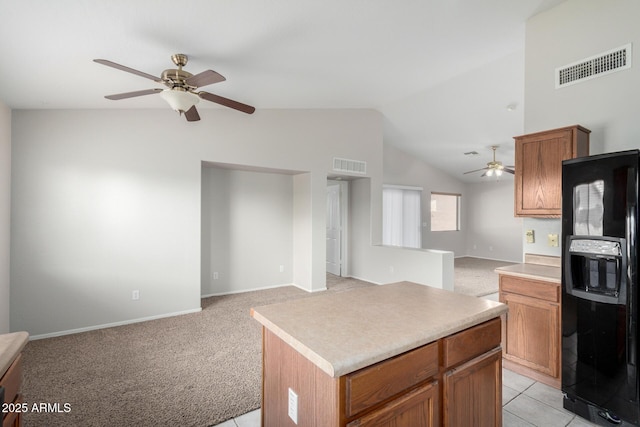 kitchen featuring a center island, open floor plan, visible vents, and black fridge