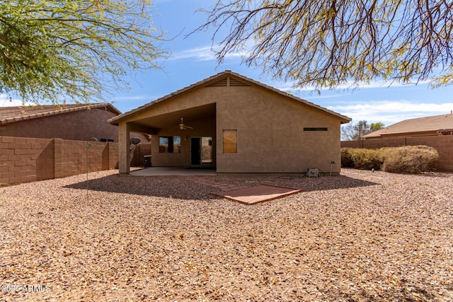 rear view of property with a ceiling fan, a fenced backyard, a tiled roof, a patio area, and stucco siding